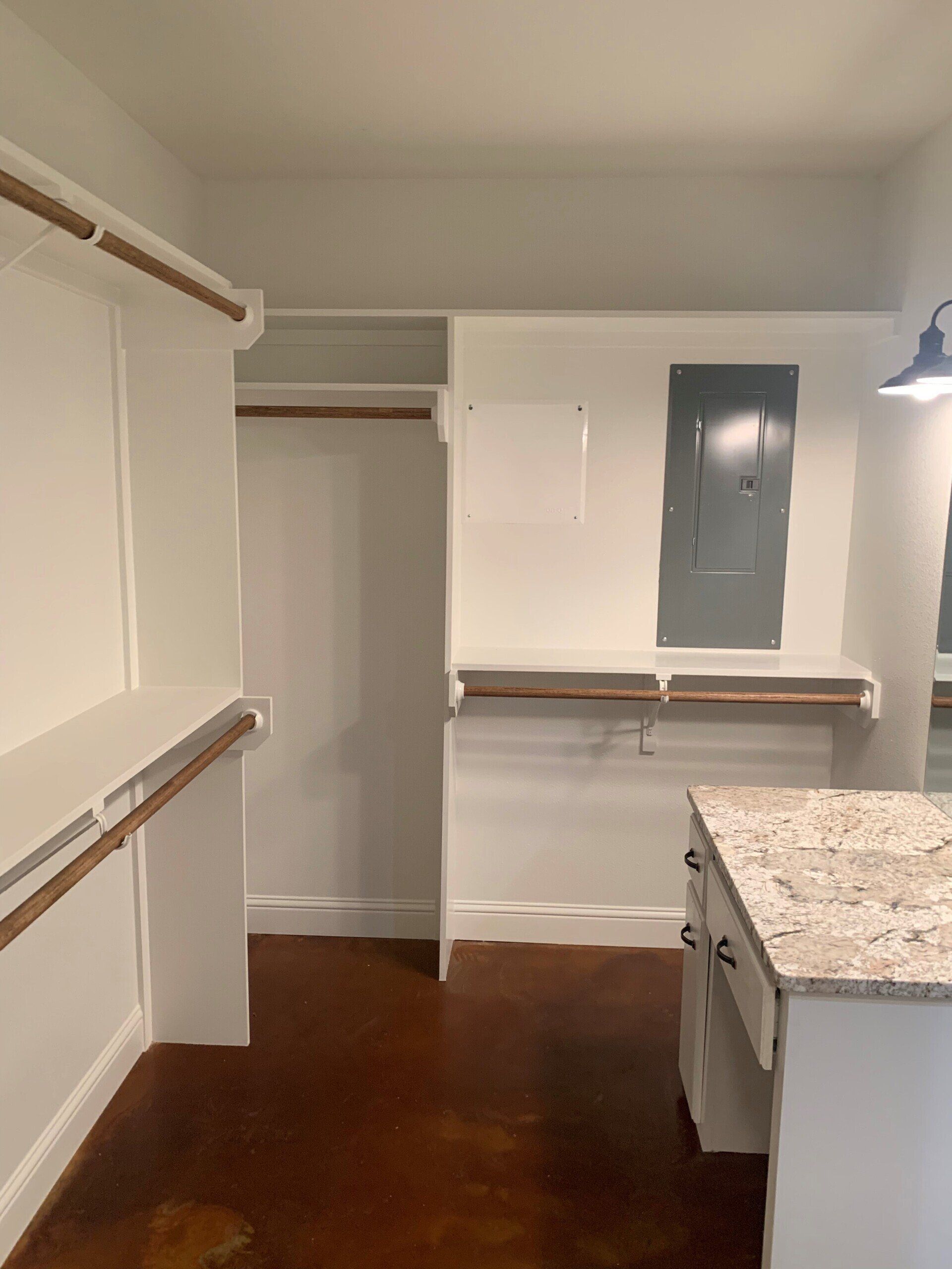 A walk in closet with lots of shelves and a counter top.