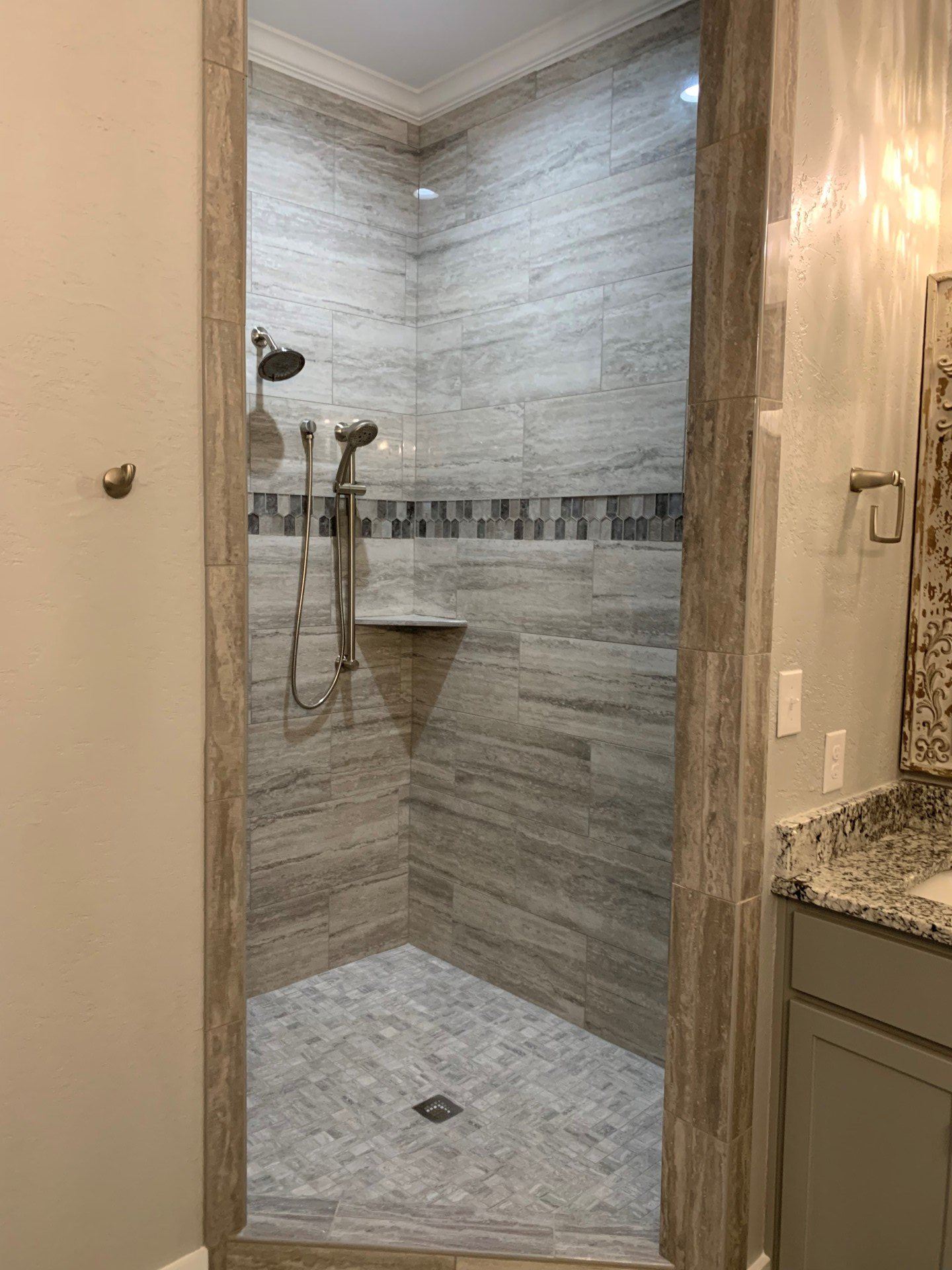 A bathroom with a walk in shower and a sink.
