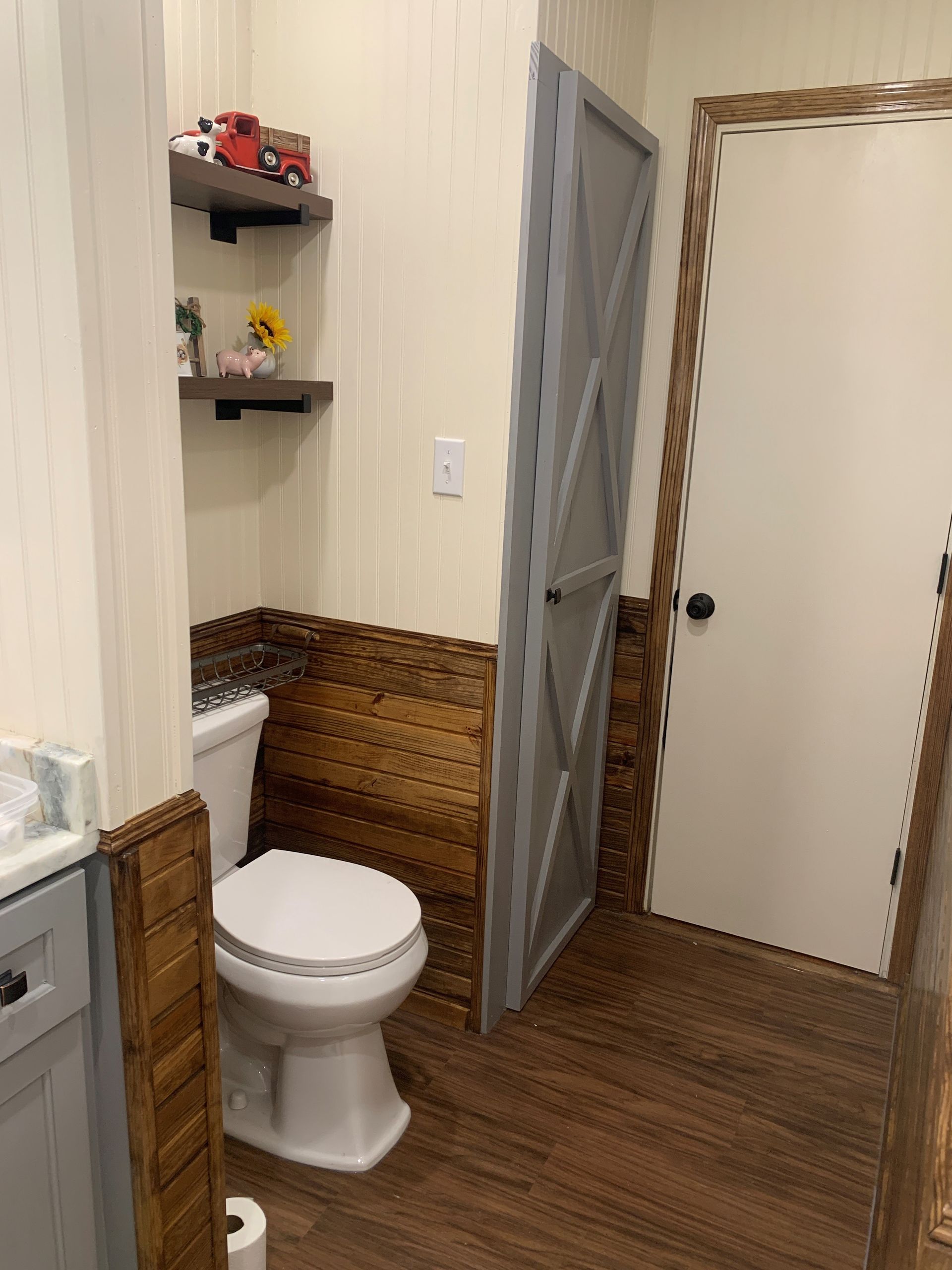 A bathroom with a toilet , sink , and door.