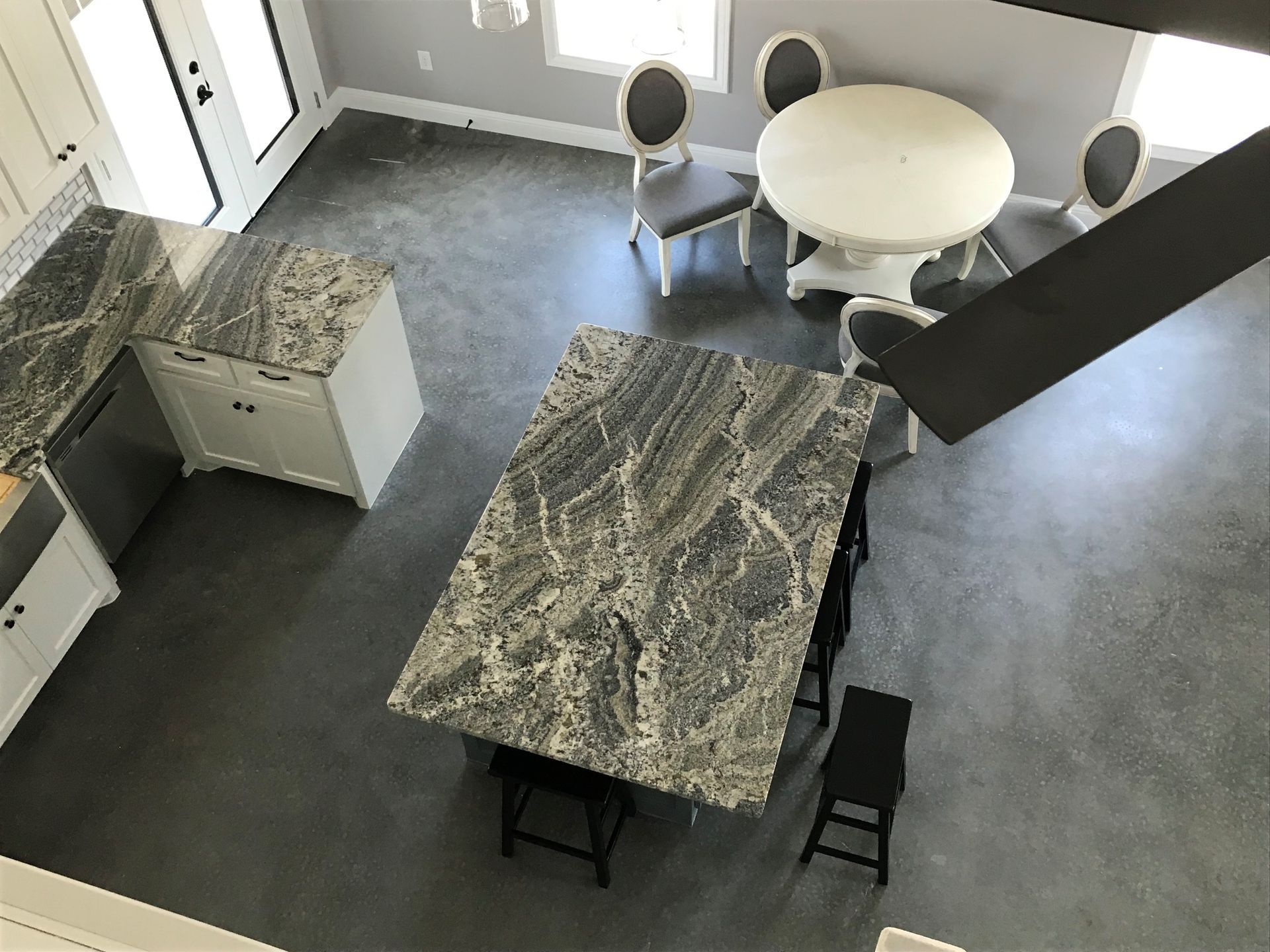 An aerial view of a kitchen with a table and chairs and a ceiling fan.