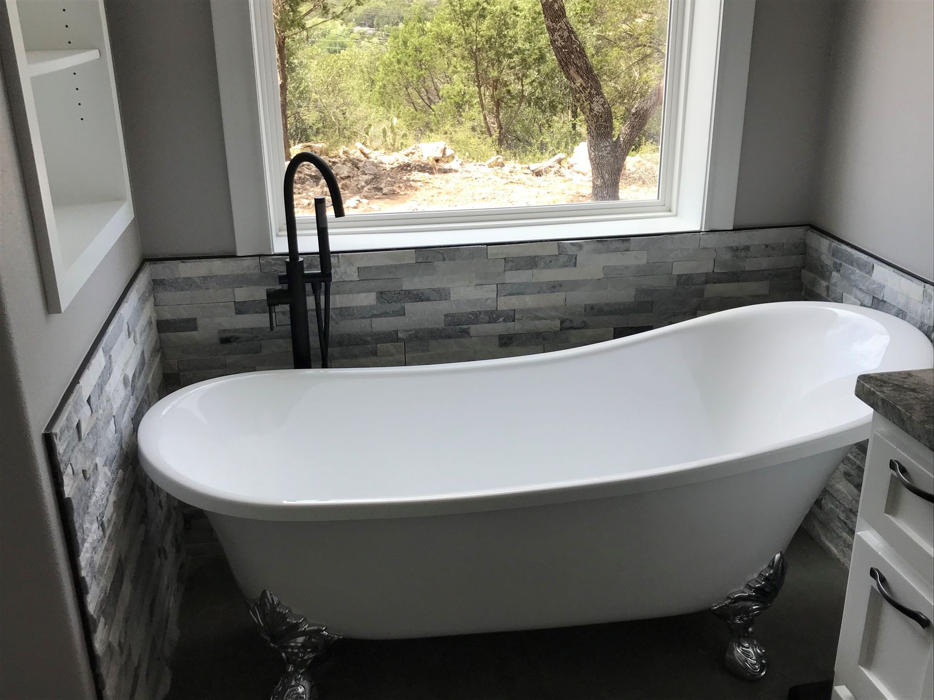 A bathtub is sitting in a bathroom next to a window.