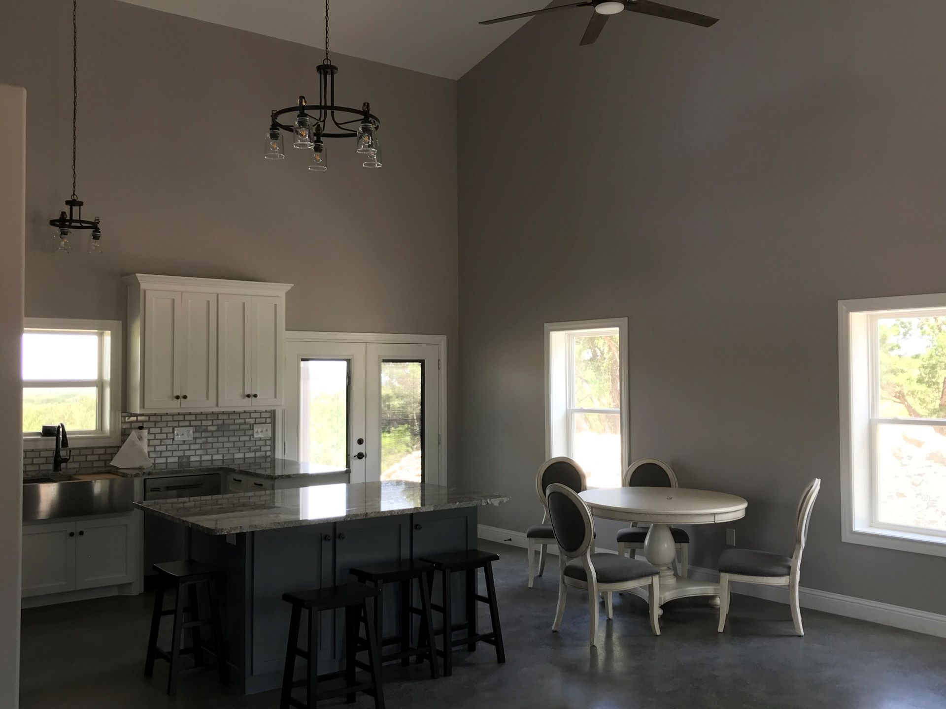 A kitchen with a table and chairs and a ceiling fan.