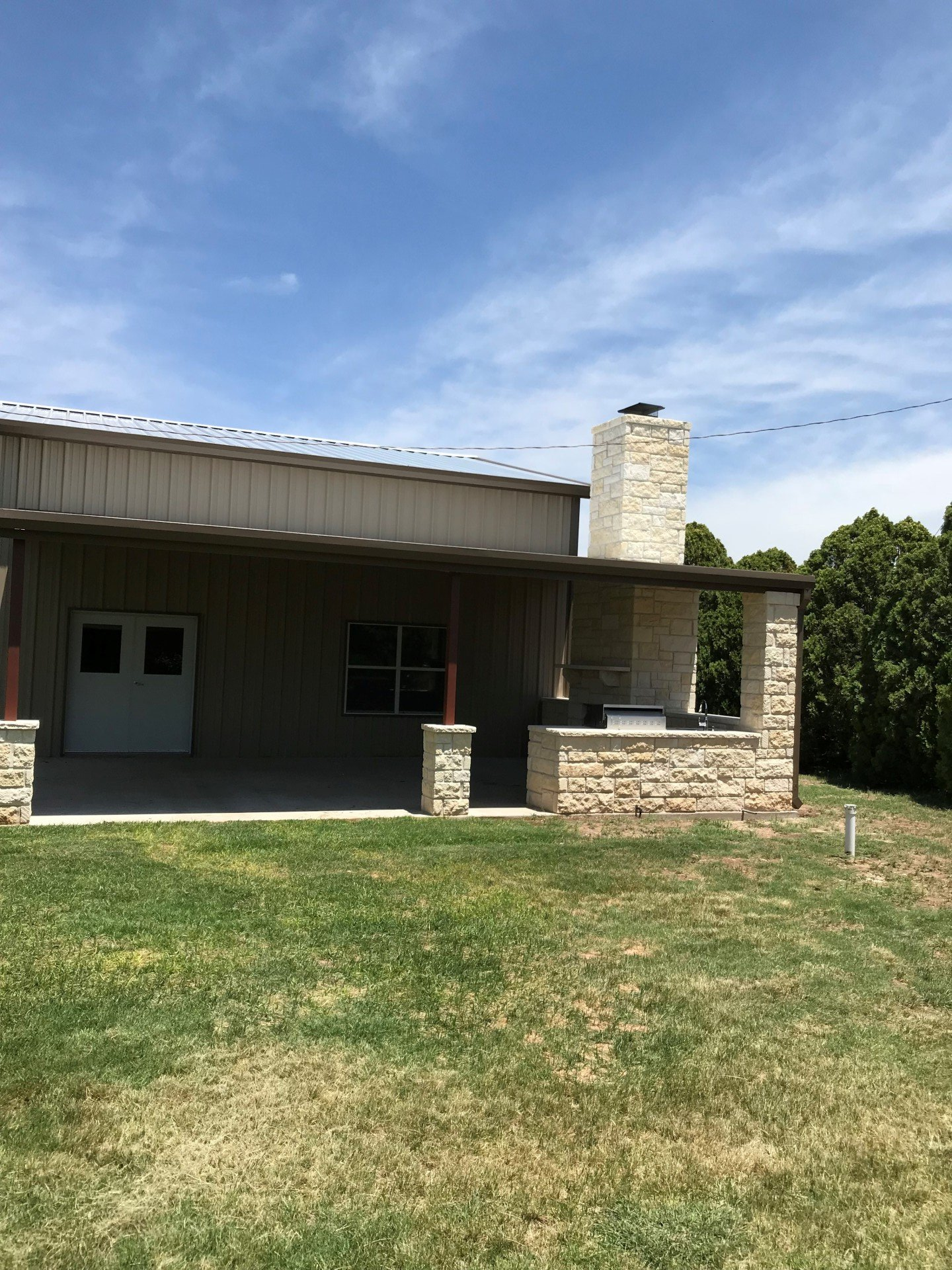 A house with a porch and a chimney on top of it.