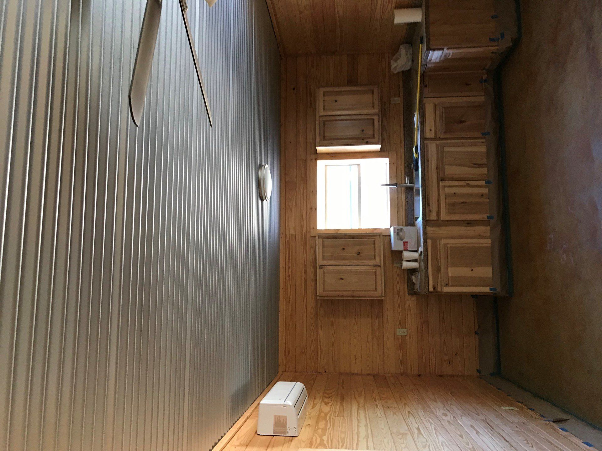 A small room with wooden cabinets and a window