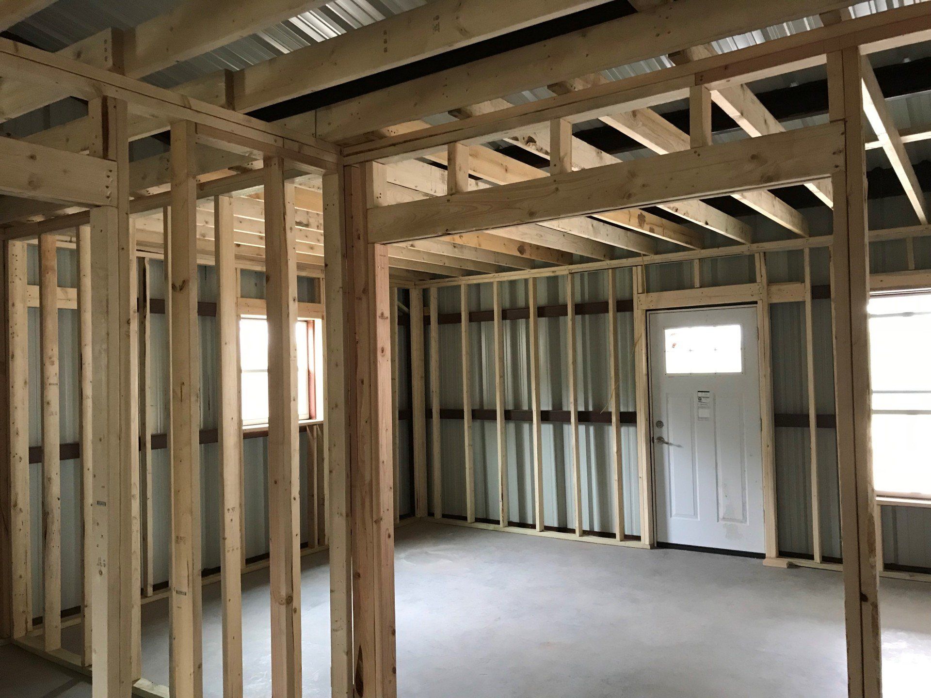 The inside of a house under construction with wooden beams and a door.