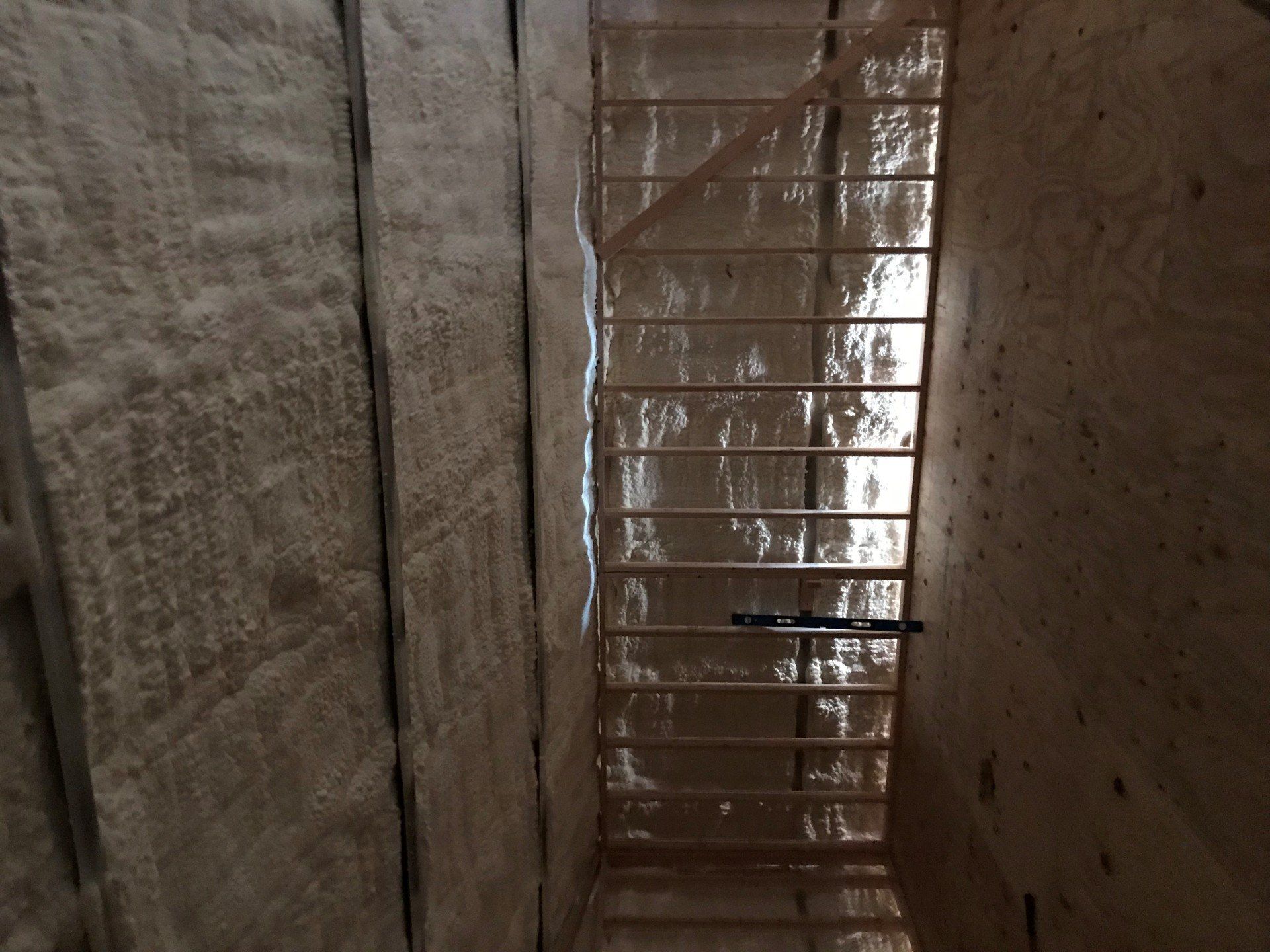 A staircase is being built in a room with insulation on the walls