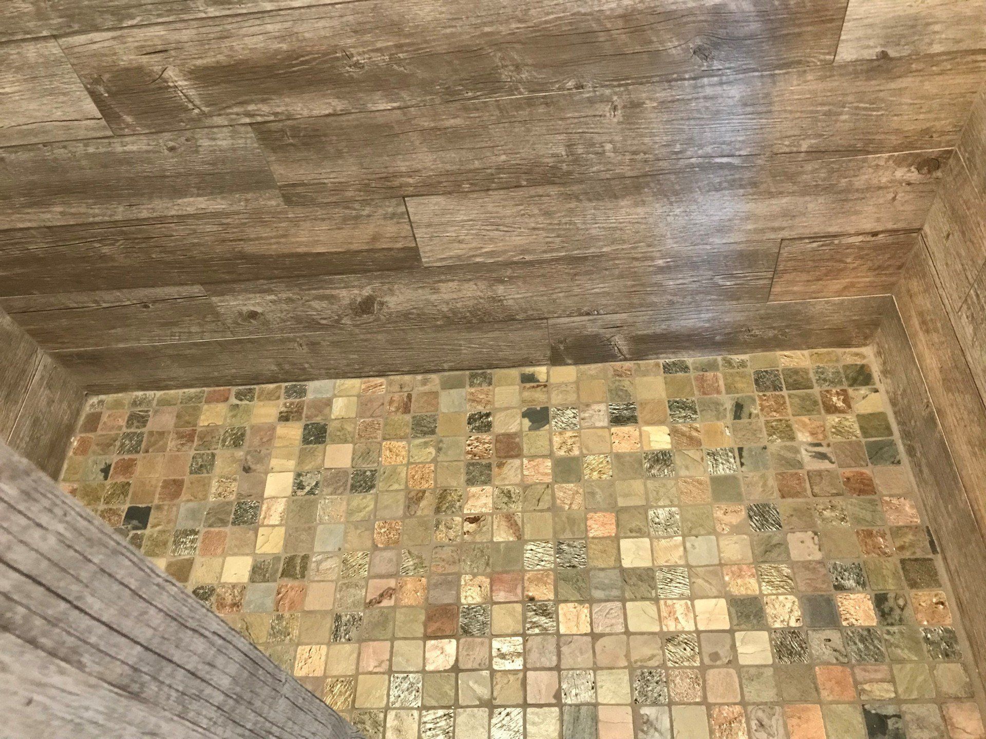 A bathroom with a tiled floor and wooden walls.