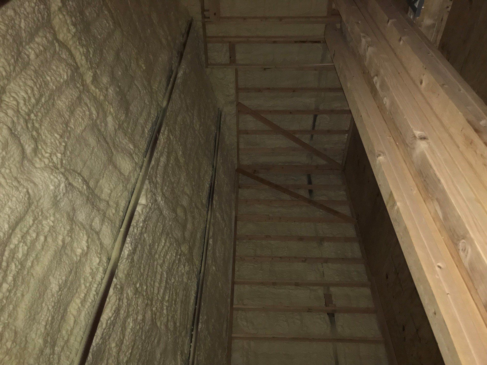 A room with a lot of foam on the wall and wooden beams.