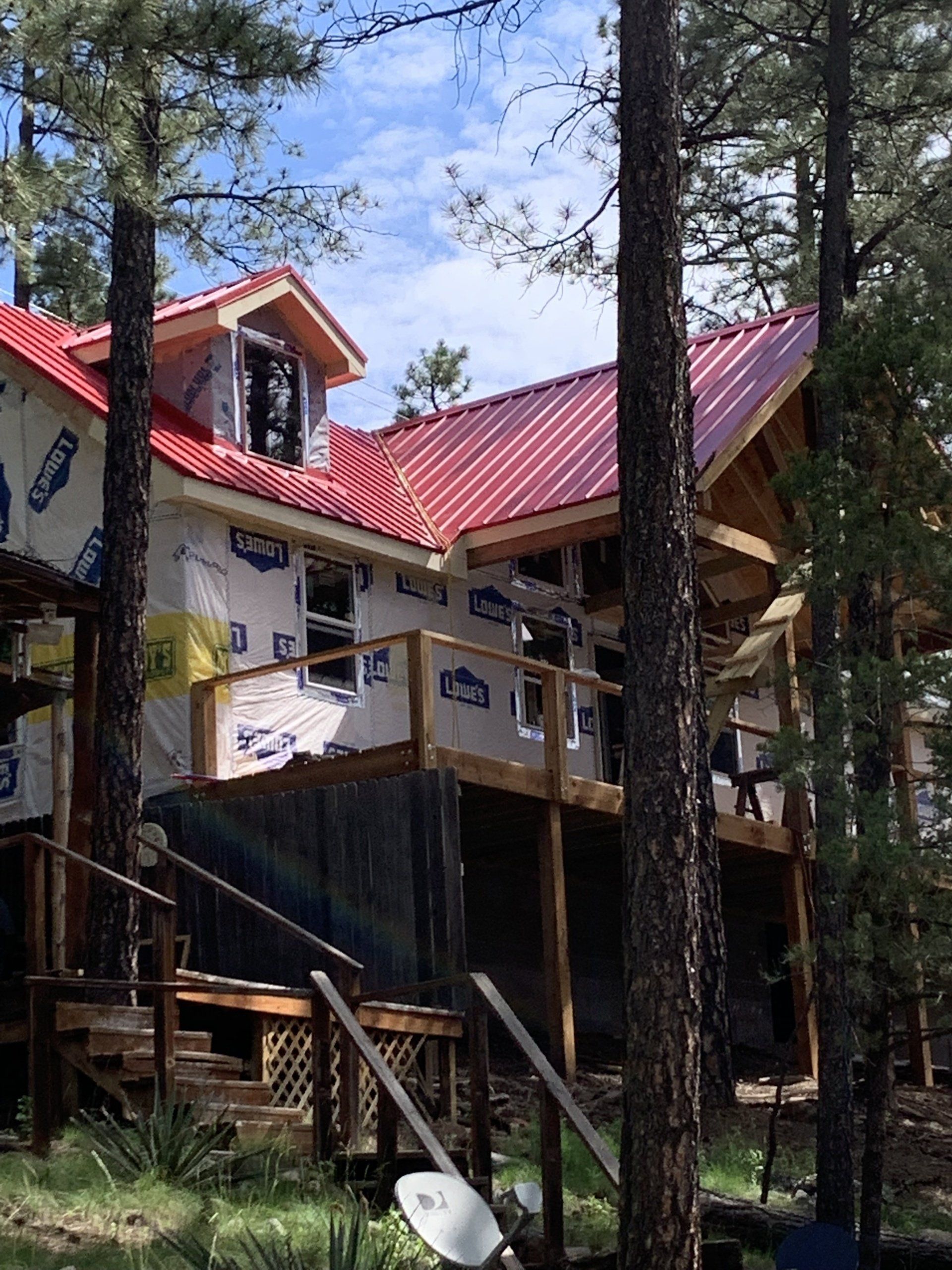 A house with a red roof is surrounded by trees