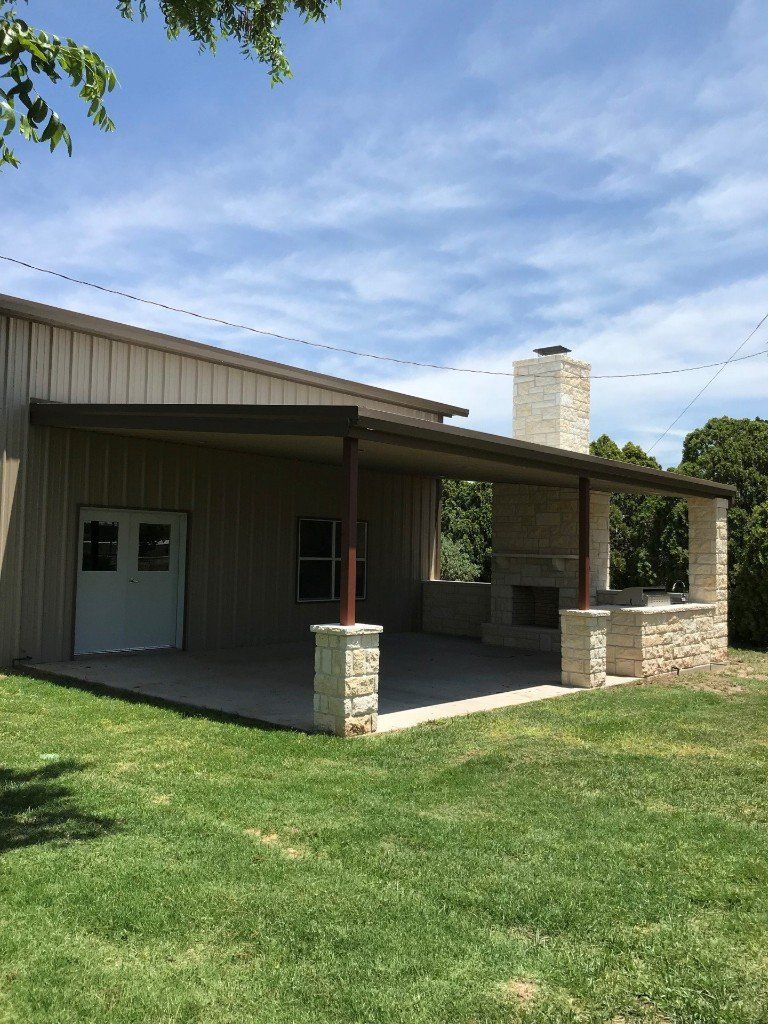 A large house with a covered porch and a stone fireplace.
