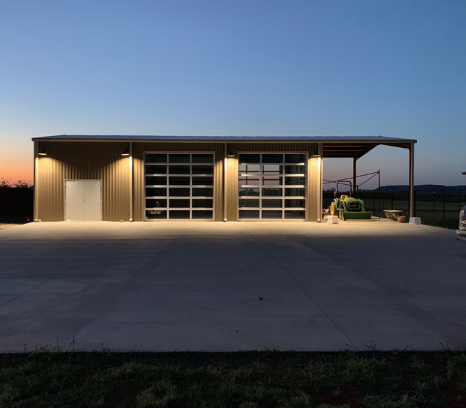A large building with a garage door is lit up at night