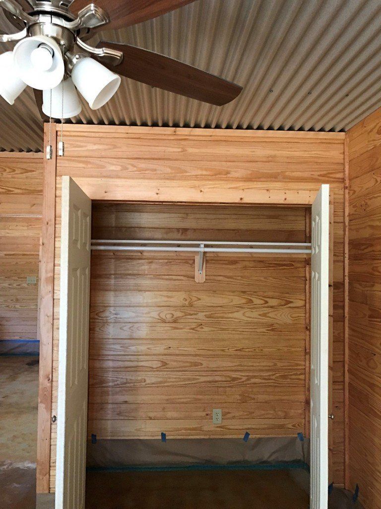 A wooden closet with a ceiling fan above it