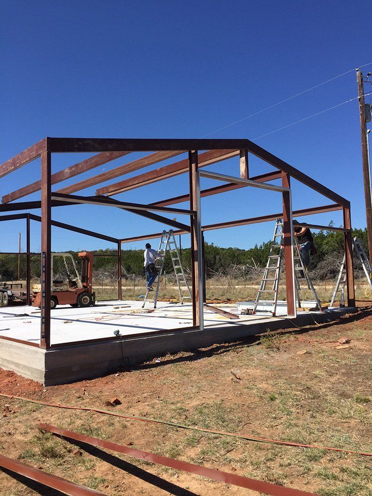 A large metal structure is being built in a field.