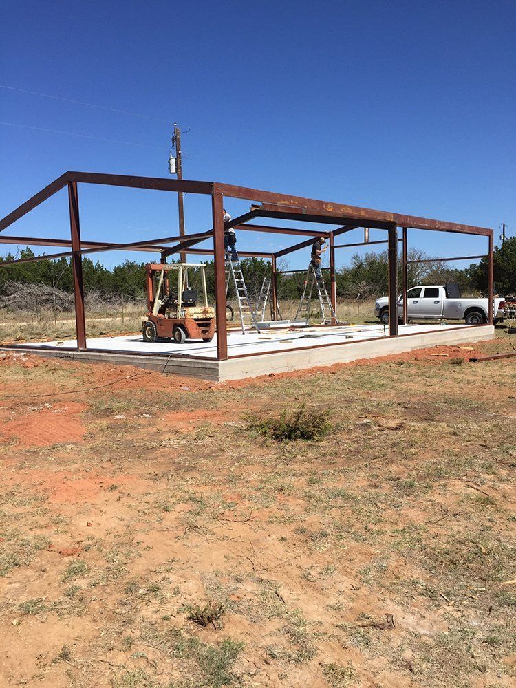 A large metal structure is being built in a field.