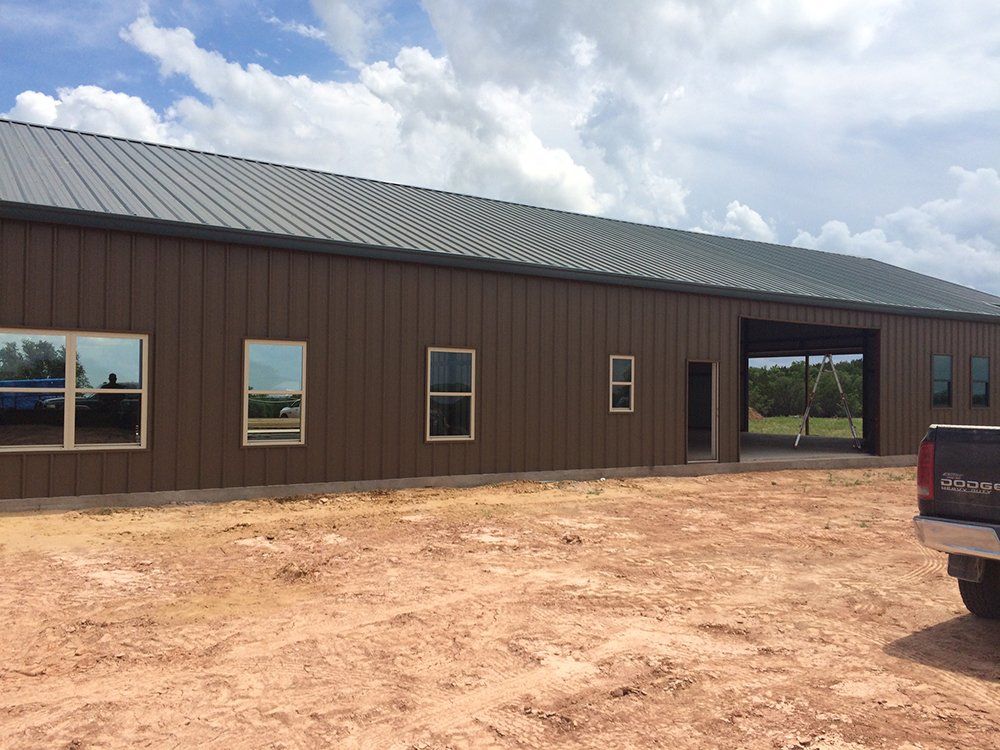 A truck is parked in front of a large brown building.