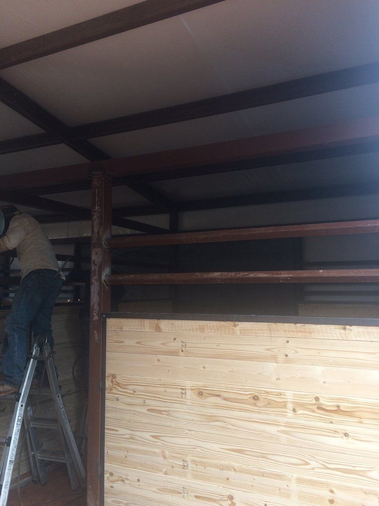 A man is standing on a ladder in a room.