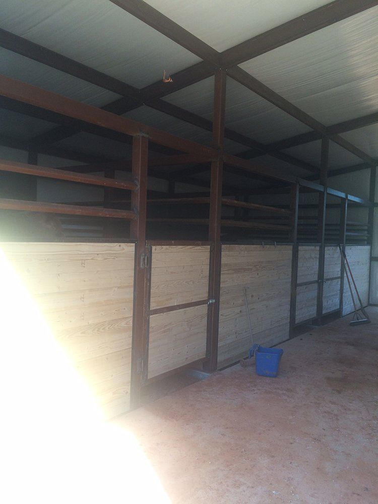 A blue bucket sits on the floor in a barn