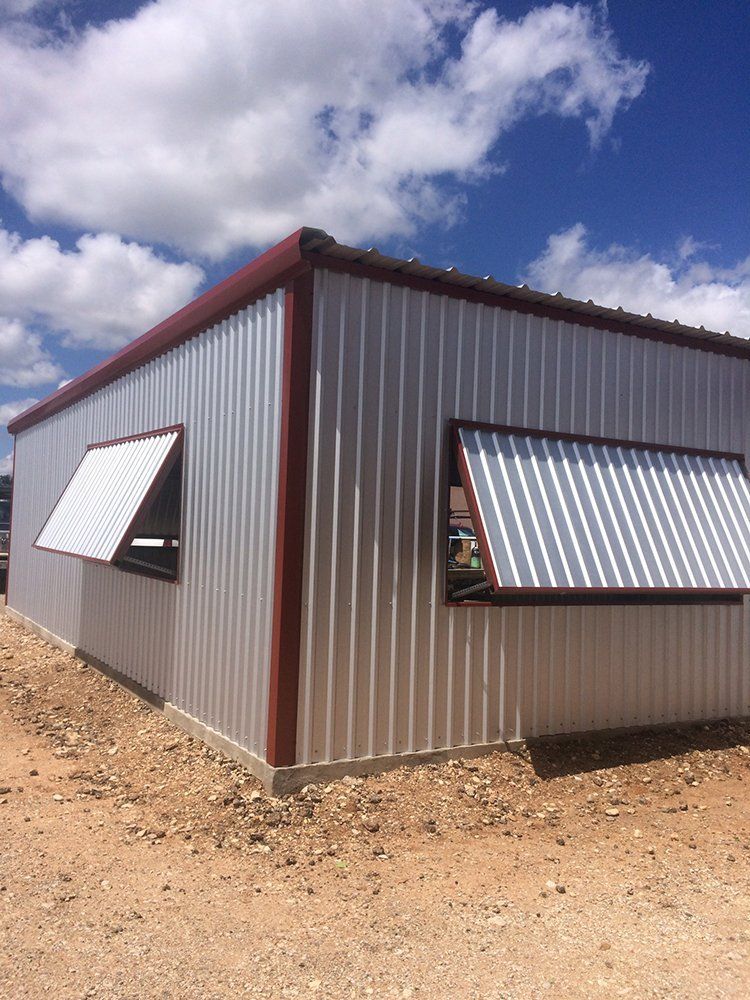 A white building with two windows on the side of it.