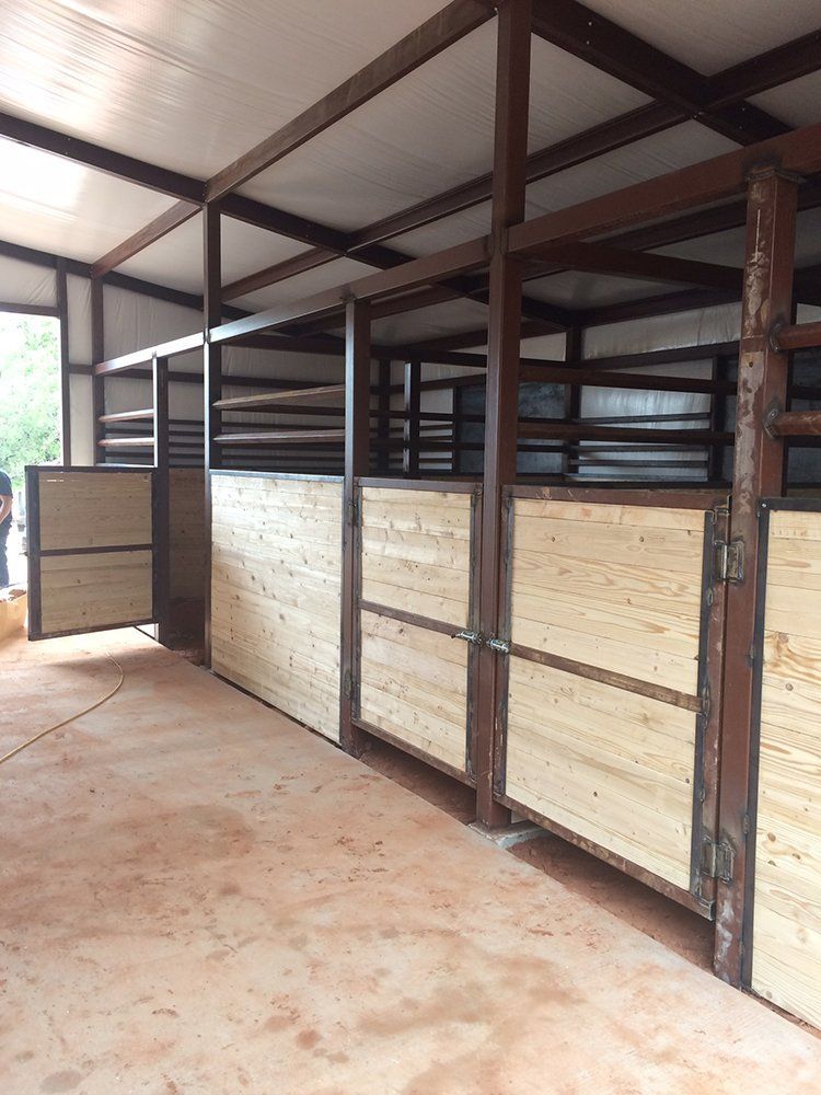 A horse stable with wooden stalls and a metal frame.