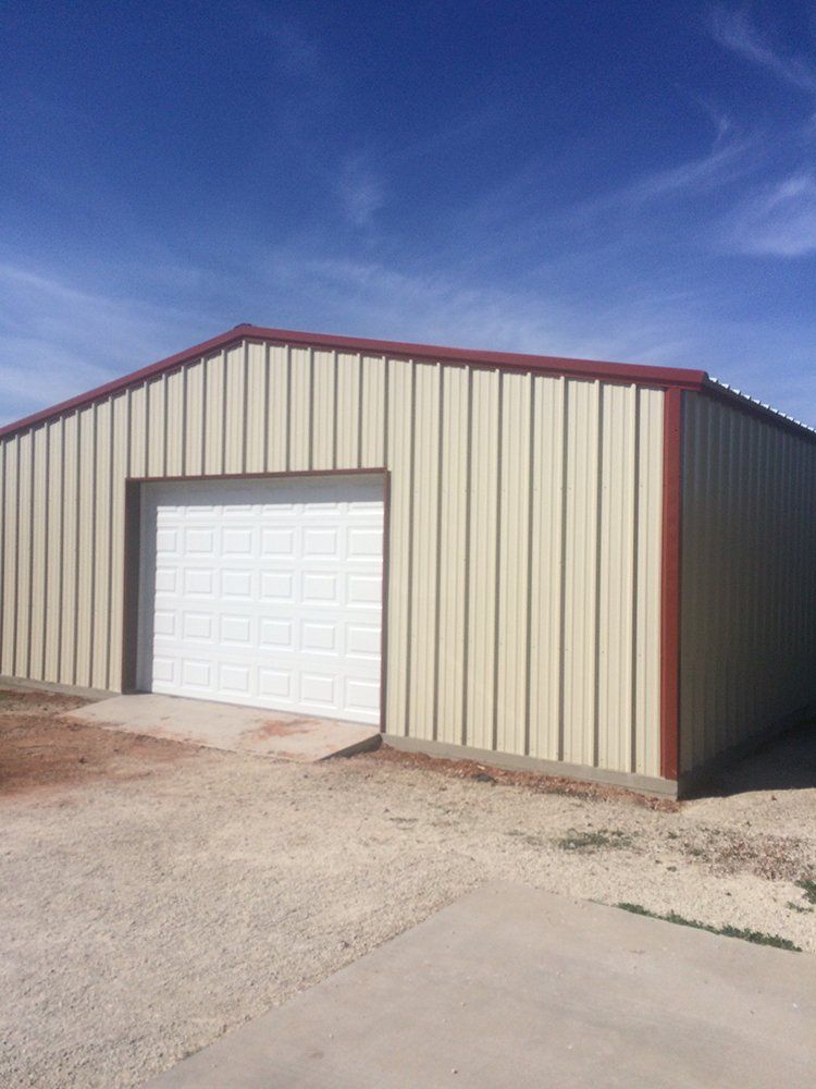 A large metal building with a white garage door.