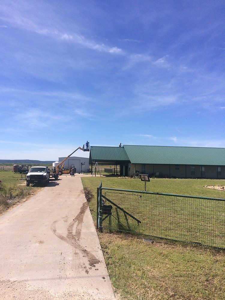 A truck is parked in front of a large building with a green roof.