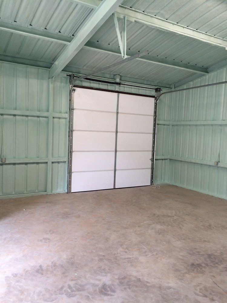 An empty garage with a white garage door