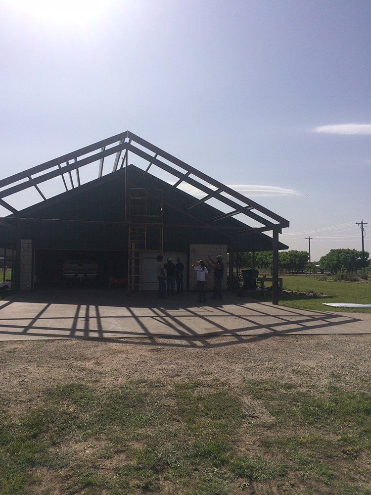 A group of people are standing in front of a building under construction.
