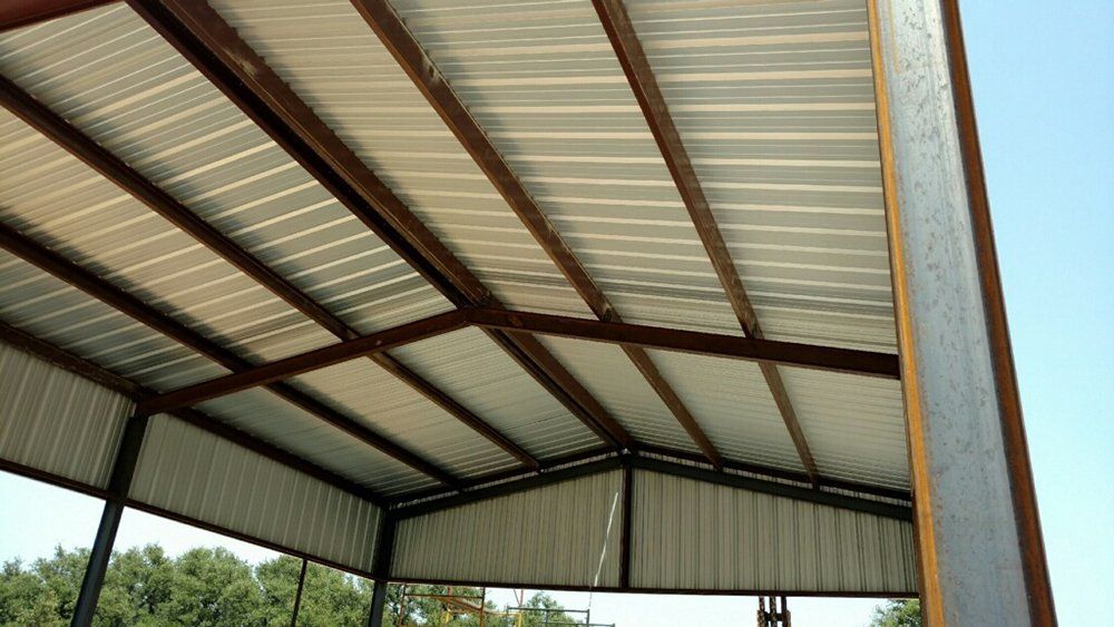 The inside of a metal building with a metal roof.