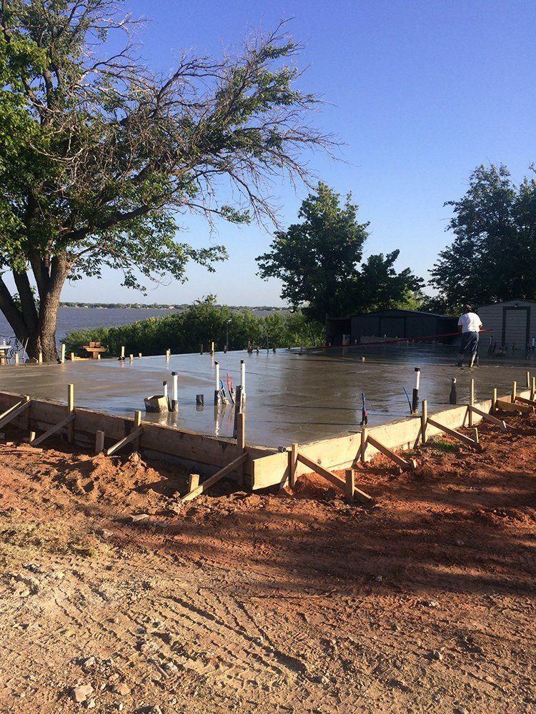 A concrete floor is being built next to a body of water.