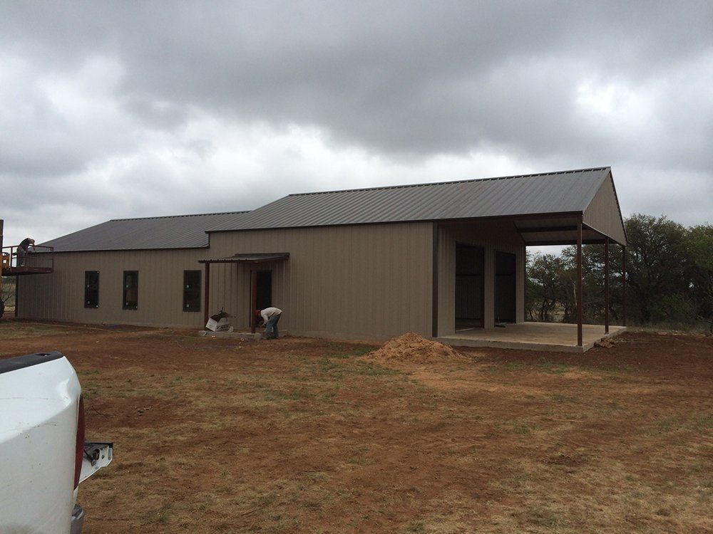 A white truck is parked in front of a large building.