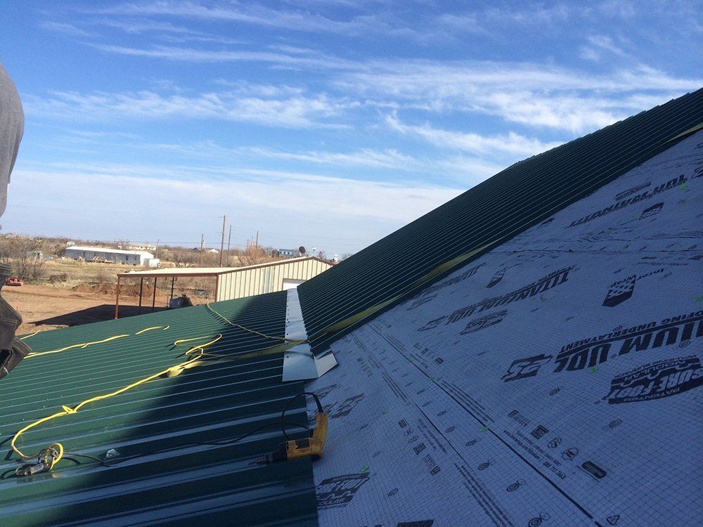 A person is standing on top of a roof with a piece of paper on it.