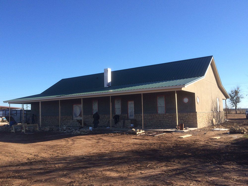 A brick house with a green roof and a porch