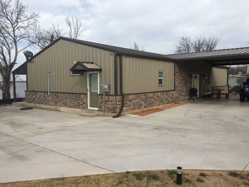A house with a carport and a driveway in front of it.