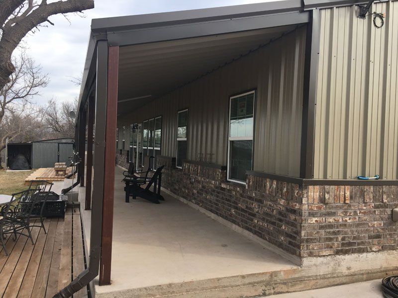 A mobile home with a porch and chairs on it.