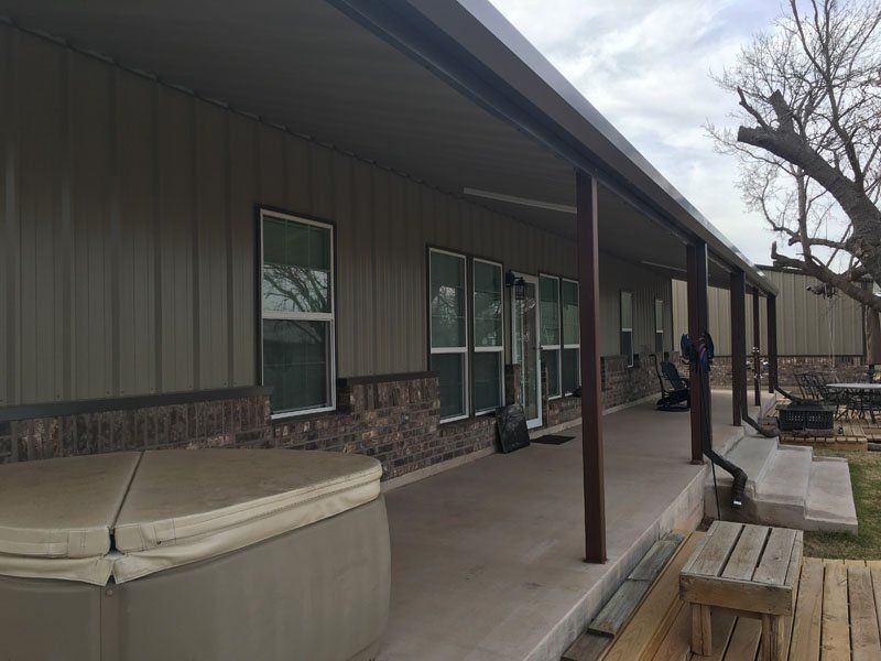 There is a hot tub on the porch of a house.