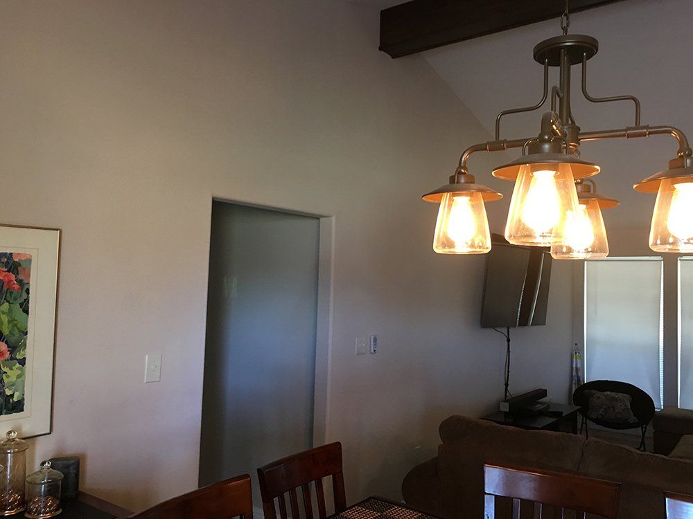 A dining room with a chandelier hanging from the ceiling