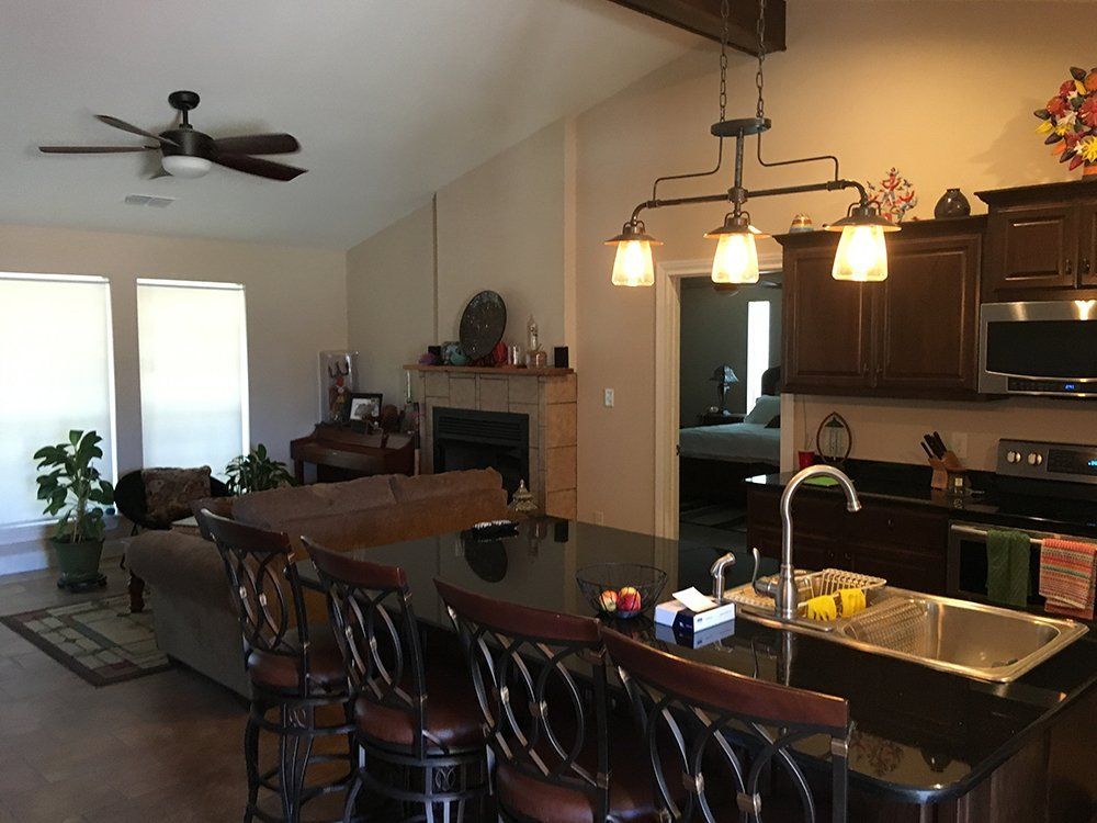 A kitchen with a sink and a ceiling fan