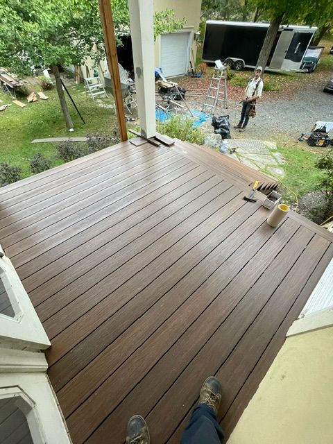Une personne se tient debout sur une terrasse en bois.