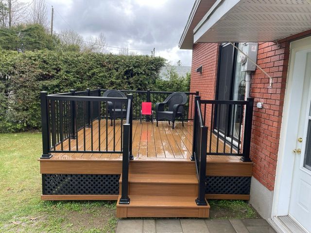 Une maison en brique avec une terrasse et des escaliers en bois