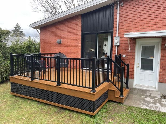 Une maison en brique avec une terrasse en bois devant