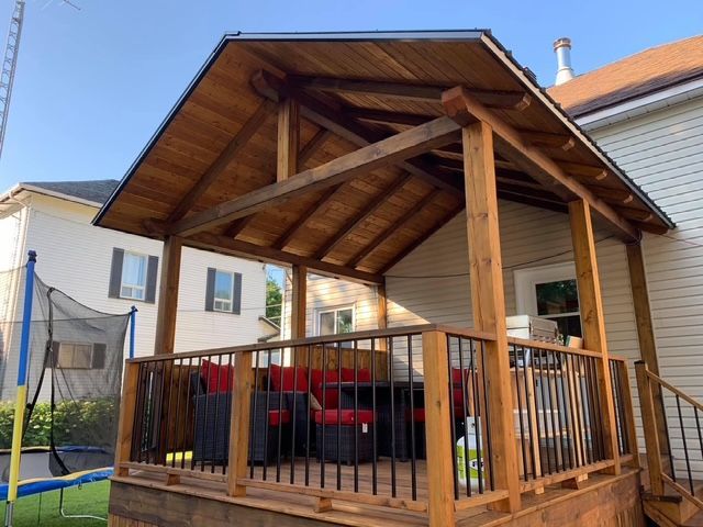 Une terrasse en bois avec un trampoline dans l'arrière-cour
