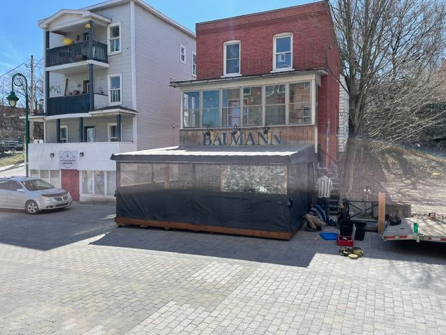 Une voiture blanche est garée devant un bâtiment avec le mot fatmann dessus.