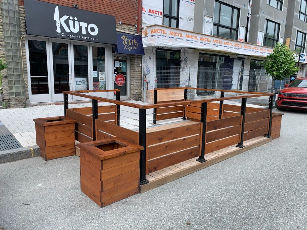 Un restaurant avec une terrasse en bois devant.