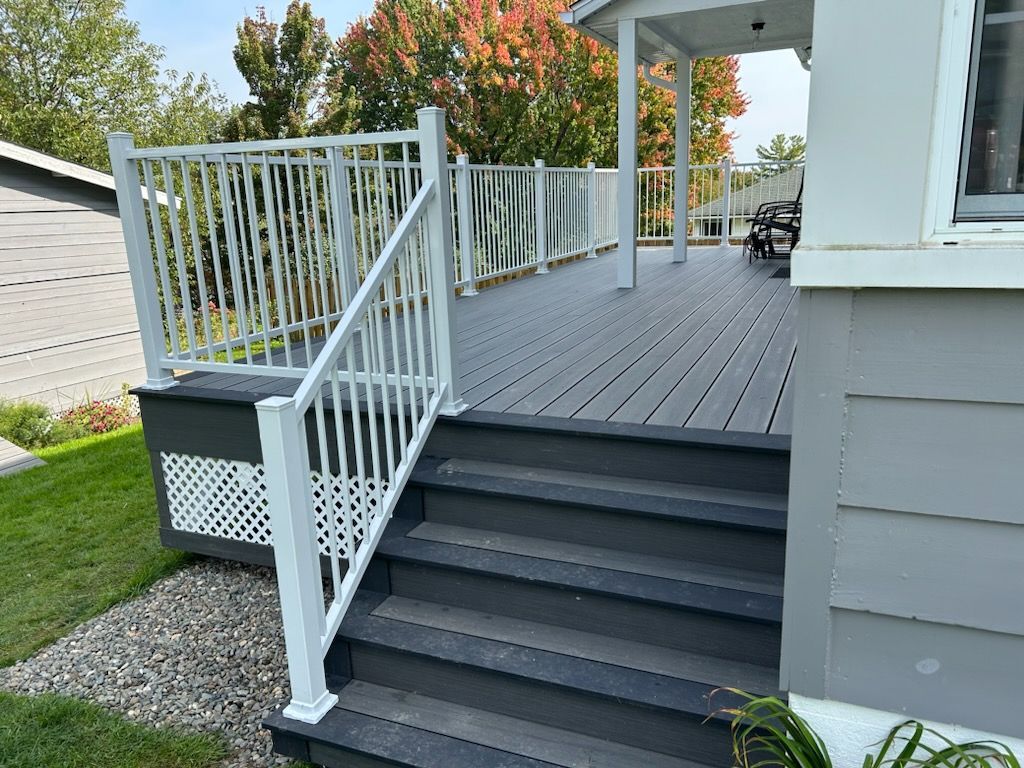 Une terrasse avec des escaliers qui y mènent et une balustrade blanche.