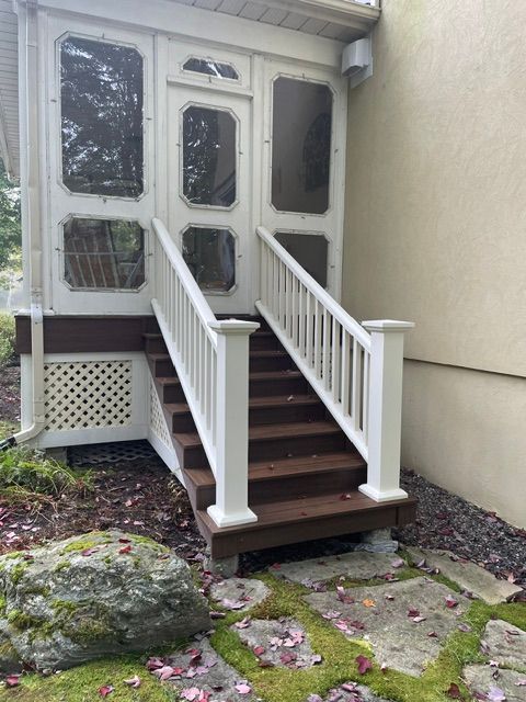 Un porche grillagé avec des escaliers qui y mènent.