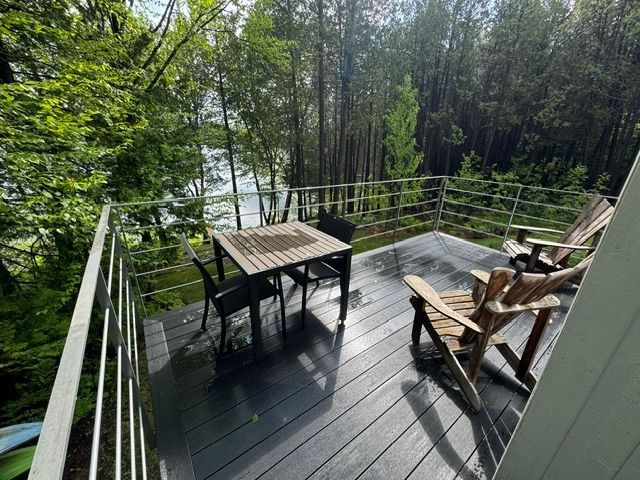 Une terrasse avec une table et des chaises donnant sur un lac.