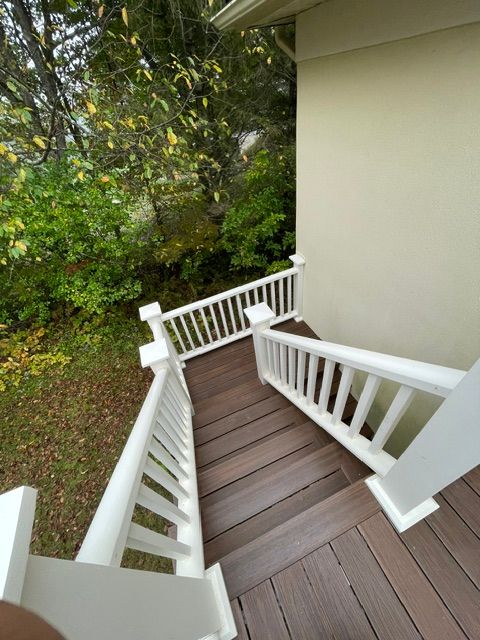 Un ensemble d'escaliers menant à une terrasse avec une balustrade blanche.