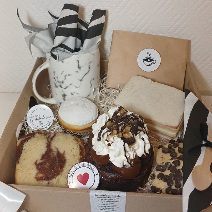 Una caja llena de una variedad de postres y una taza.