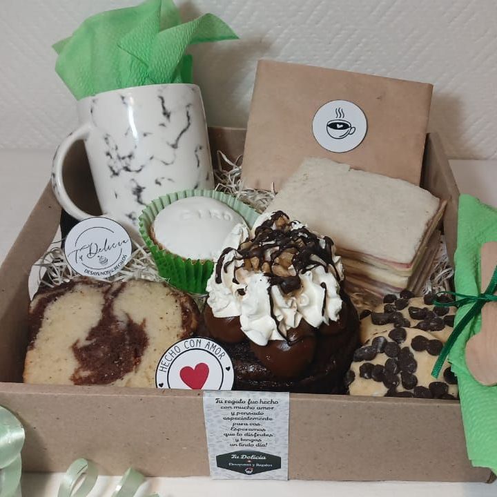 Una caja llena de una variedad de postres y una taza.