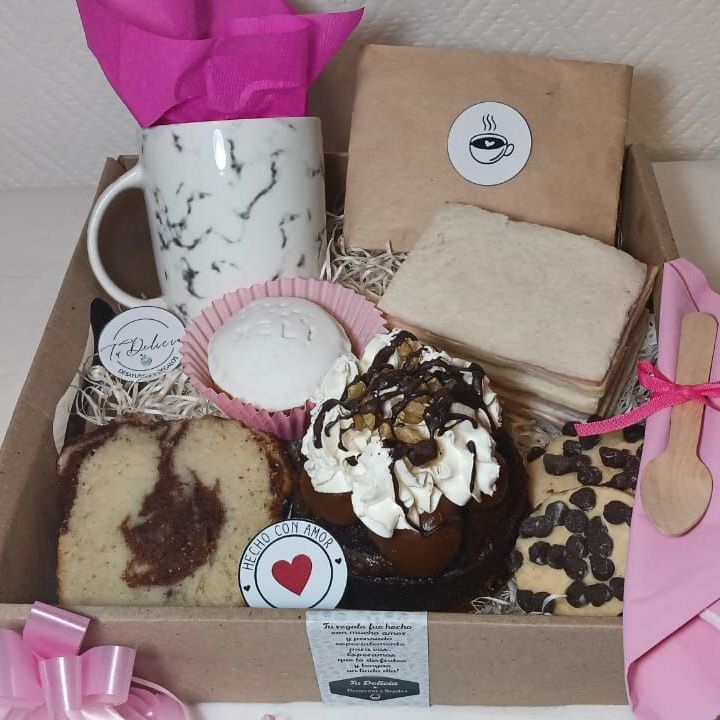 Una caja llena de una variedad de postres y una taza.